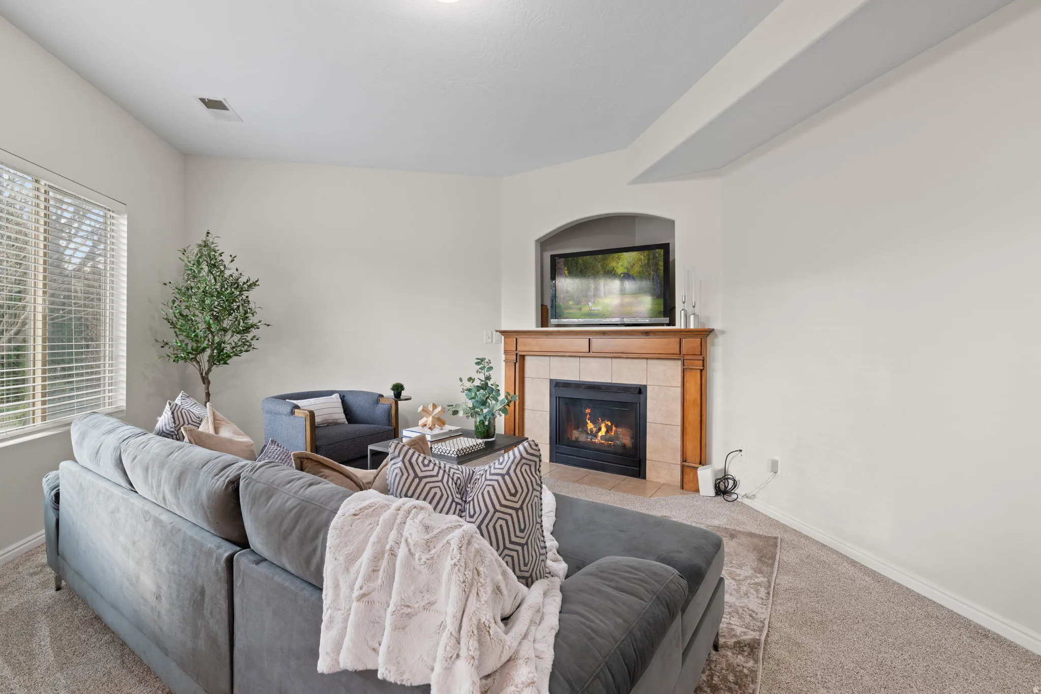 Living room with carpet and a tiled fireplace