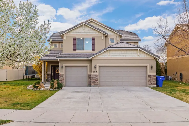 Craftsman inspired home with a trampoline, concrete driveway, stone siding, and stucco siding