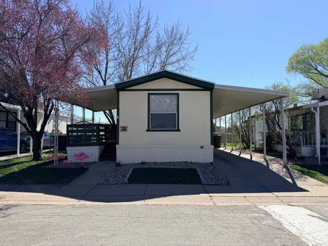 Manufactured / mobile home with a porch, a carport, and driveway