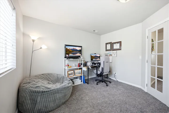 Carpeted home office featuring baseboards
