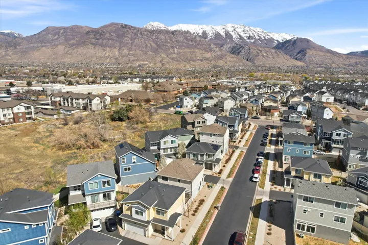 Aerial view of property and surrounding area with a mountainous background and nearby suburban area