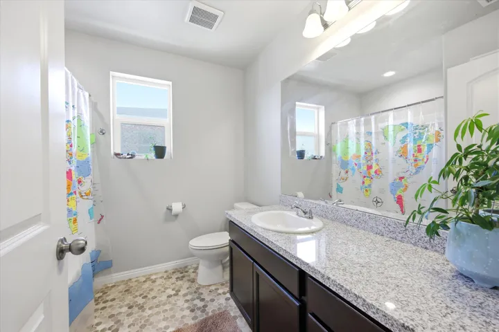 Full bath featuring vanity, curtained shower, and light tile patterned floors