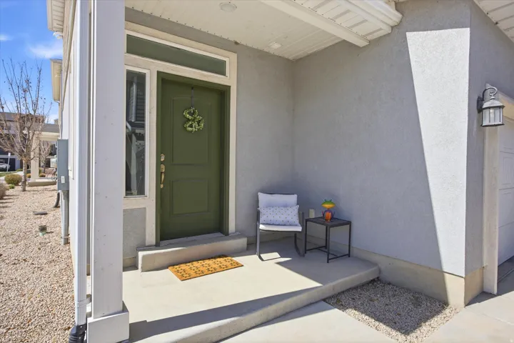 Property entrance with stucco siding and a porch