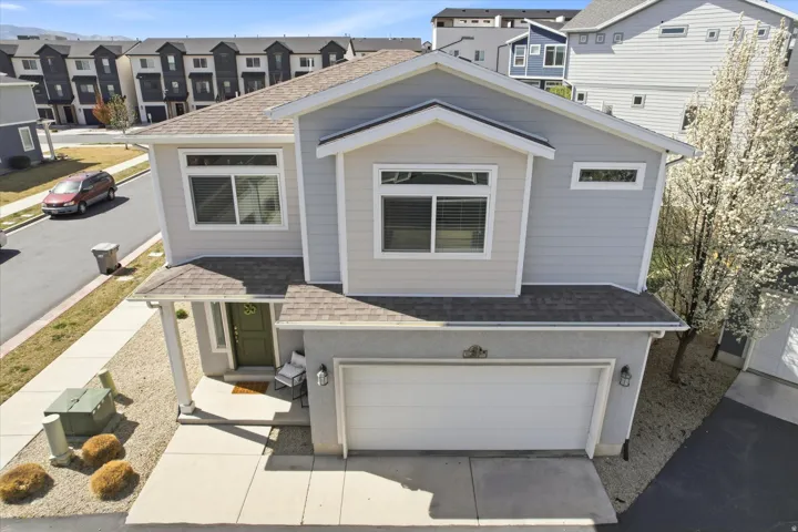 View of front of property with roof with shingles, a residential view, a garage, and driveway