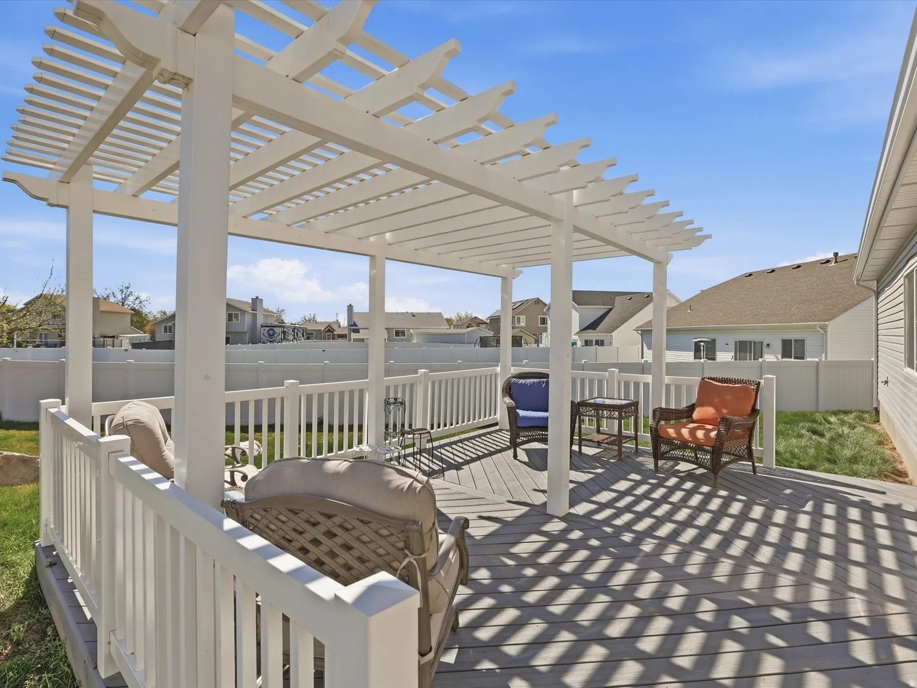 Fenced backyard featuring a residential view, a wooden deck, an outdoor living space, and a grill