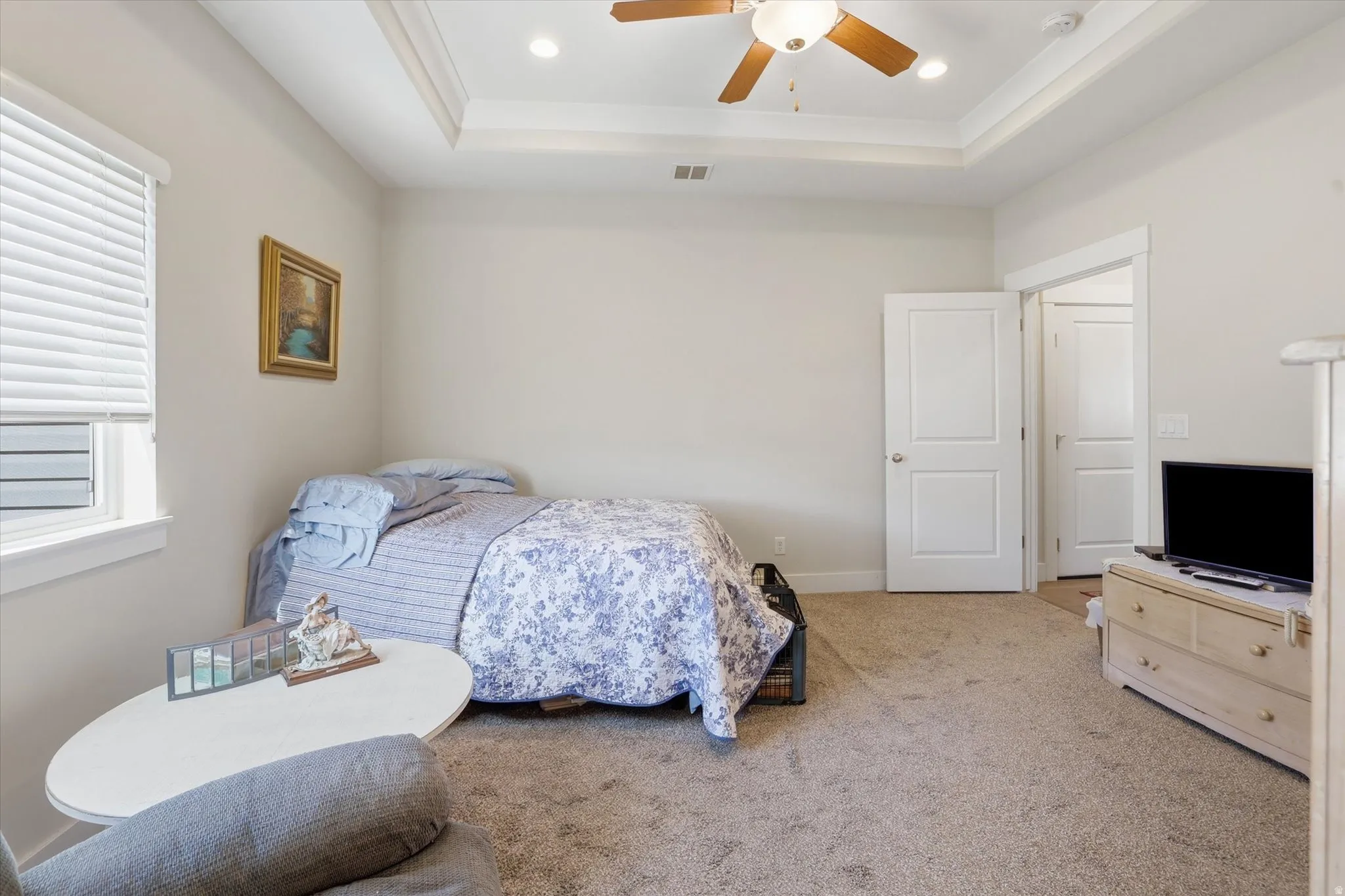 Bedroom featuring carpet flooring, a ceiling fan, a tray ceiling, and recessed lighting