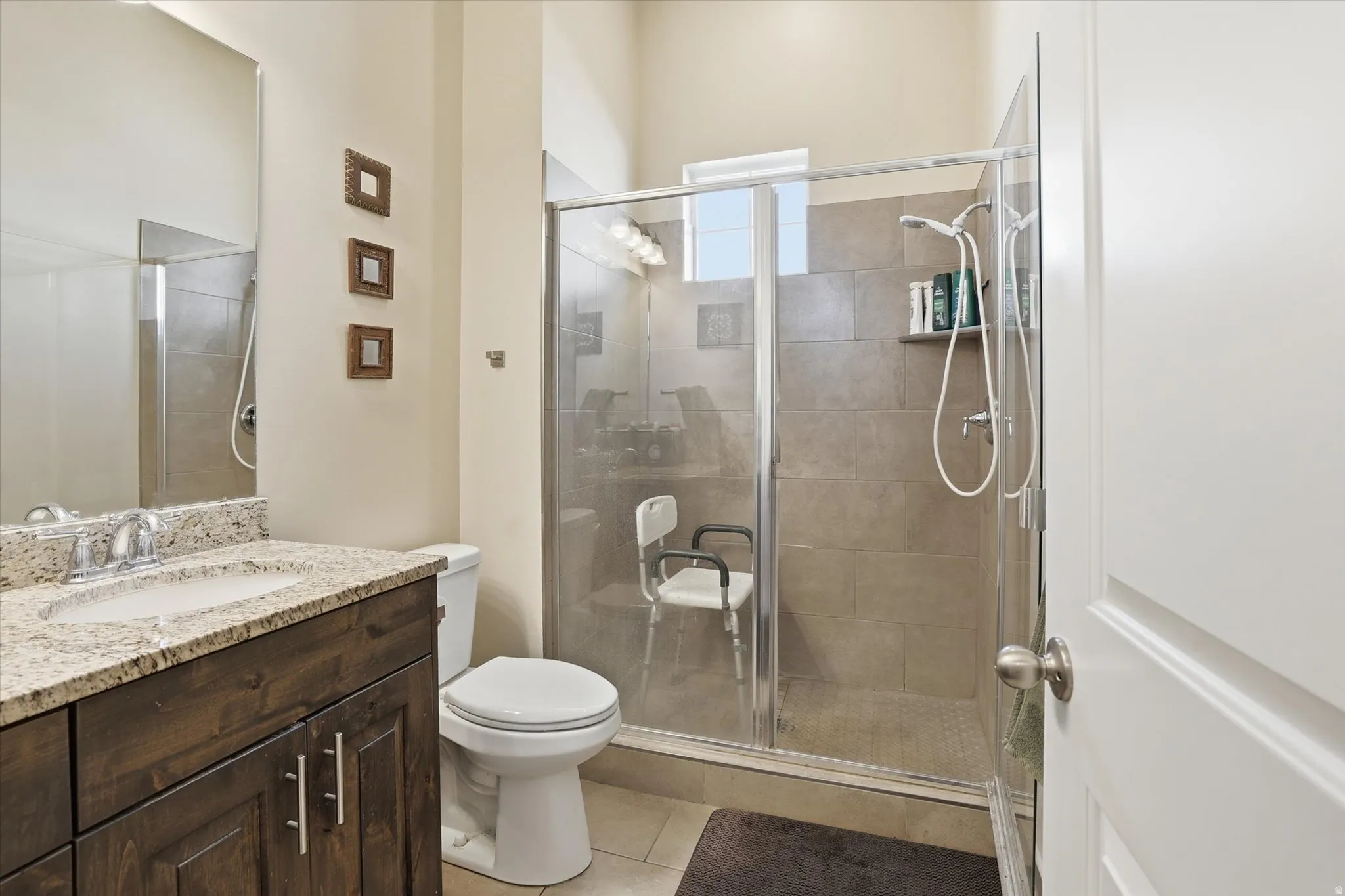 Bathroom with vanity, a shower stall, and light tile patterned flooring