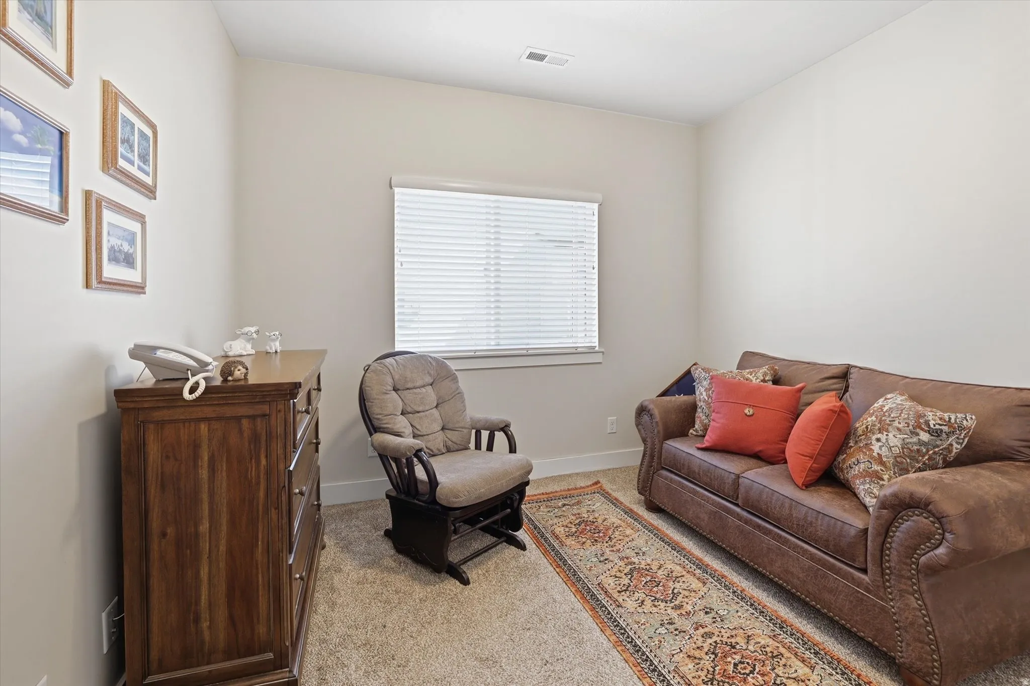 Living area featuring light colored carpet and baseboards