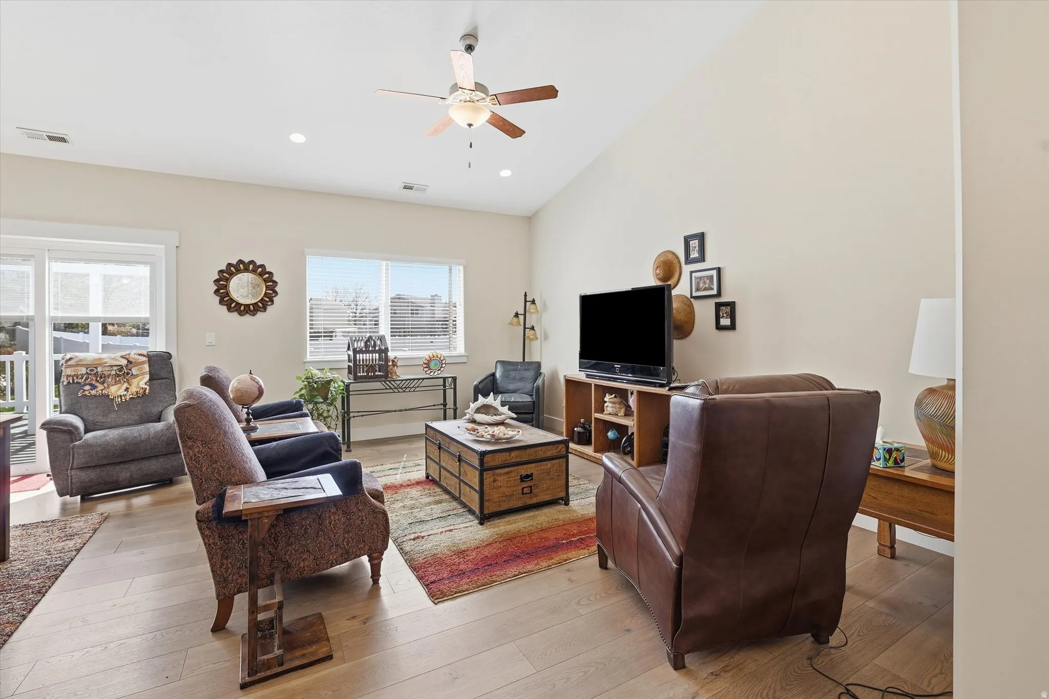 Living area with light wood finished floors, ceiling fan, recessed lighting, and lofted ceiling