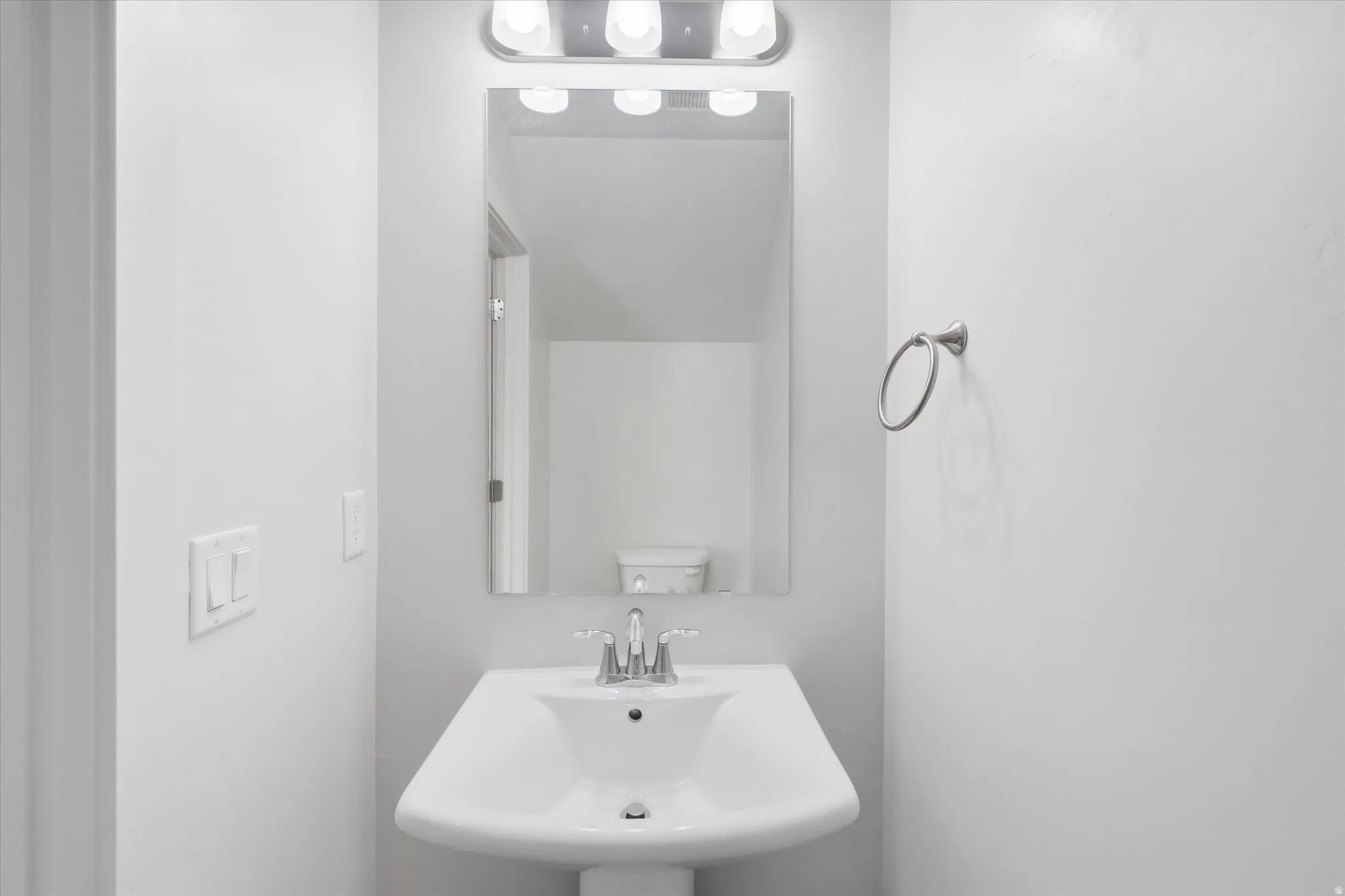 Downstairs Half bath featuring a sink and toilet