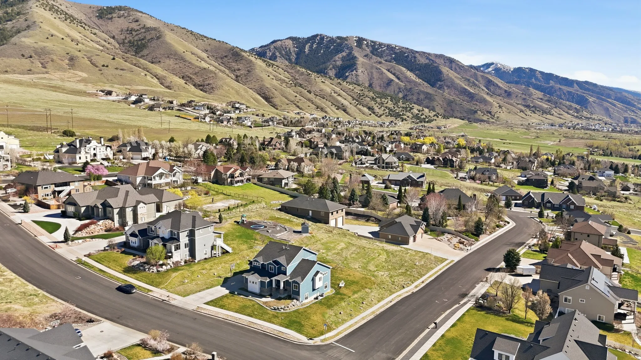 Aerial overview of property's location featuring nearby suburban area and a mountain backdrop