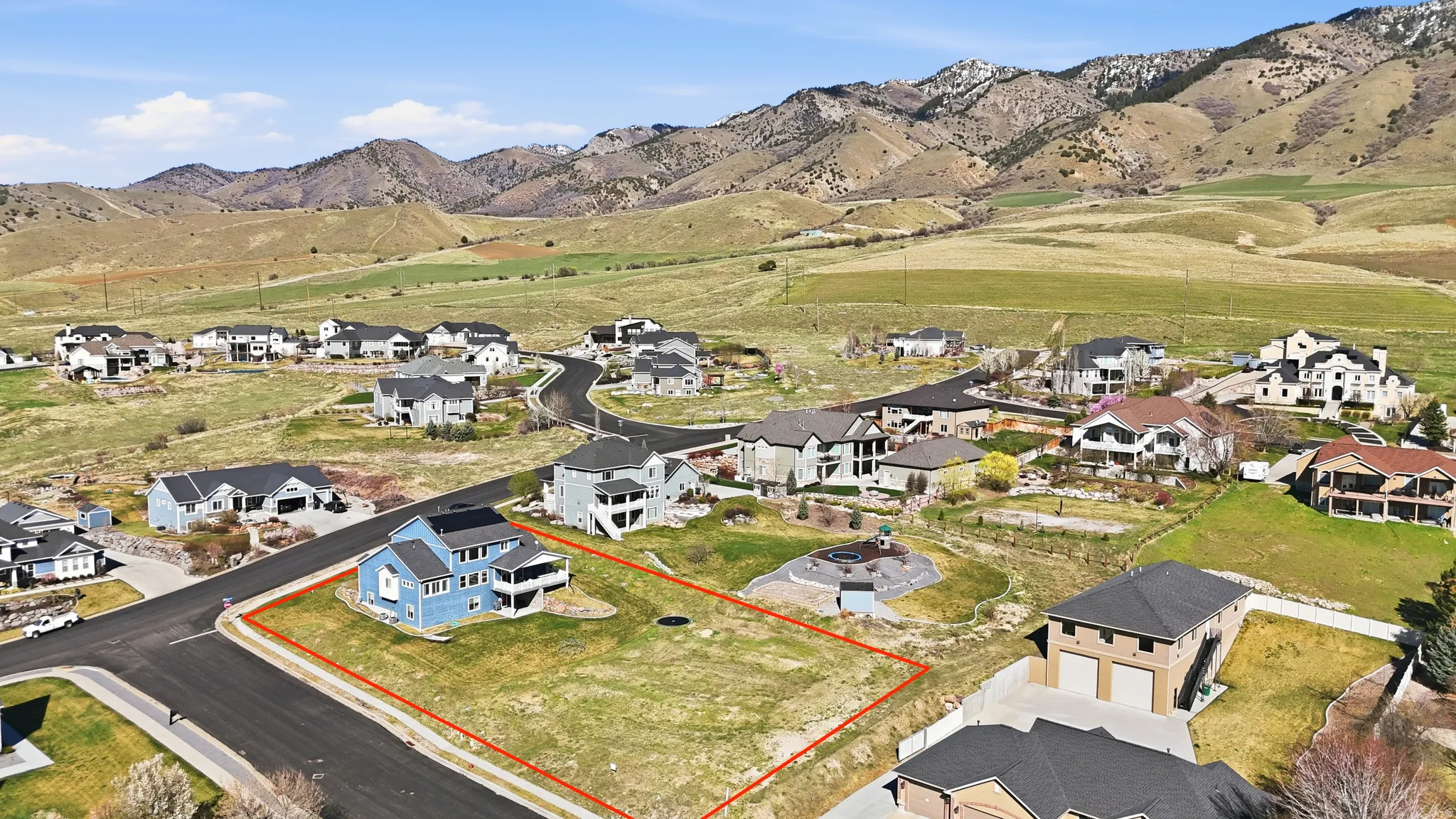 Expansive land parcel outlined in red, featuring a paved road frontage