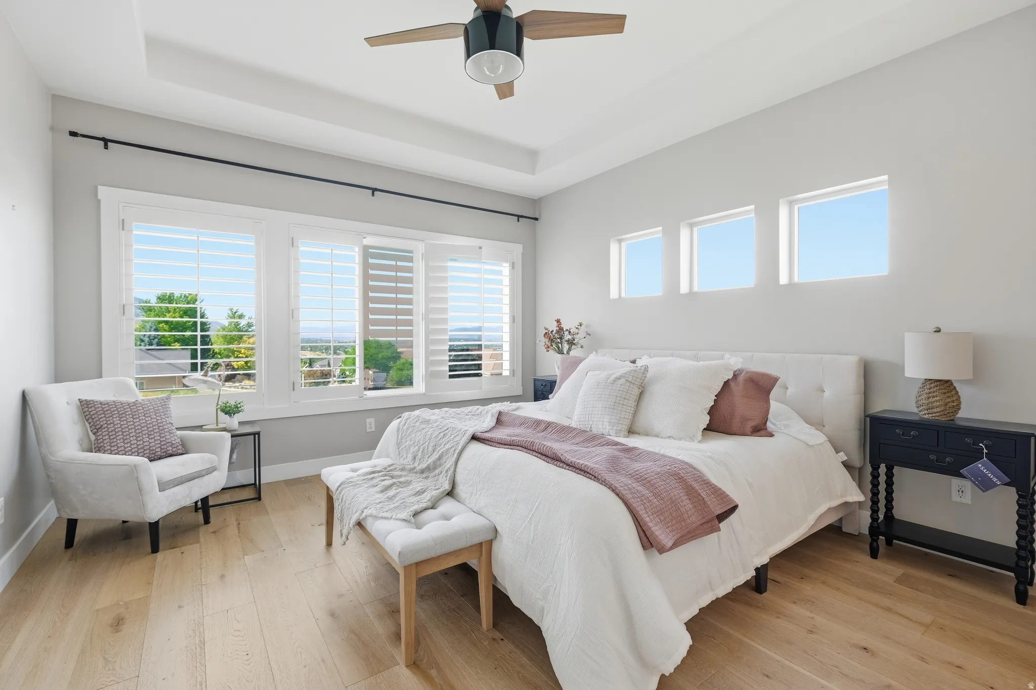 Bedroom featuring light wood-finish flooring and a tray ceiling