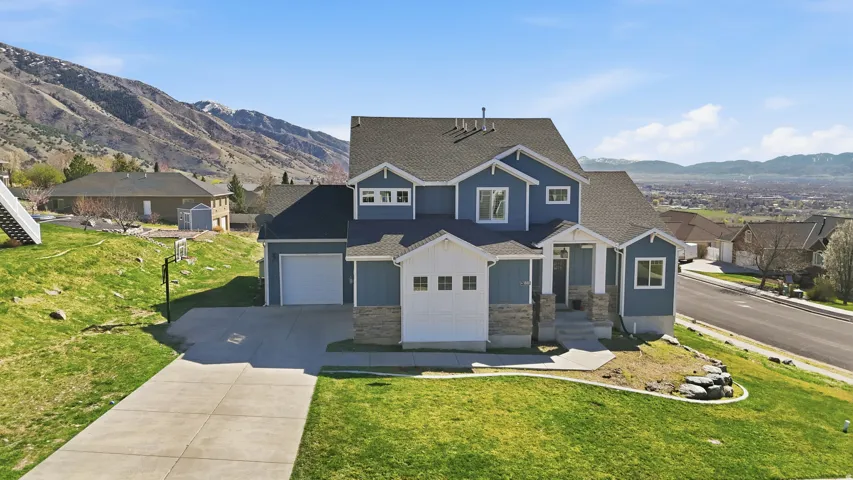 Contemporary two-story residence featuring a blue and white siding exterior with stone accents