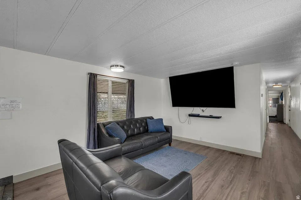 Living area with light wood finished floors and a textured ceiling