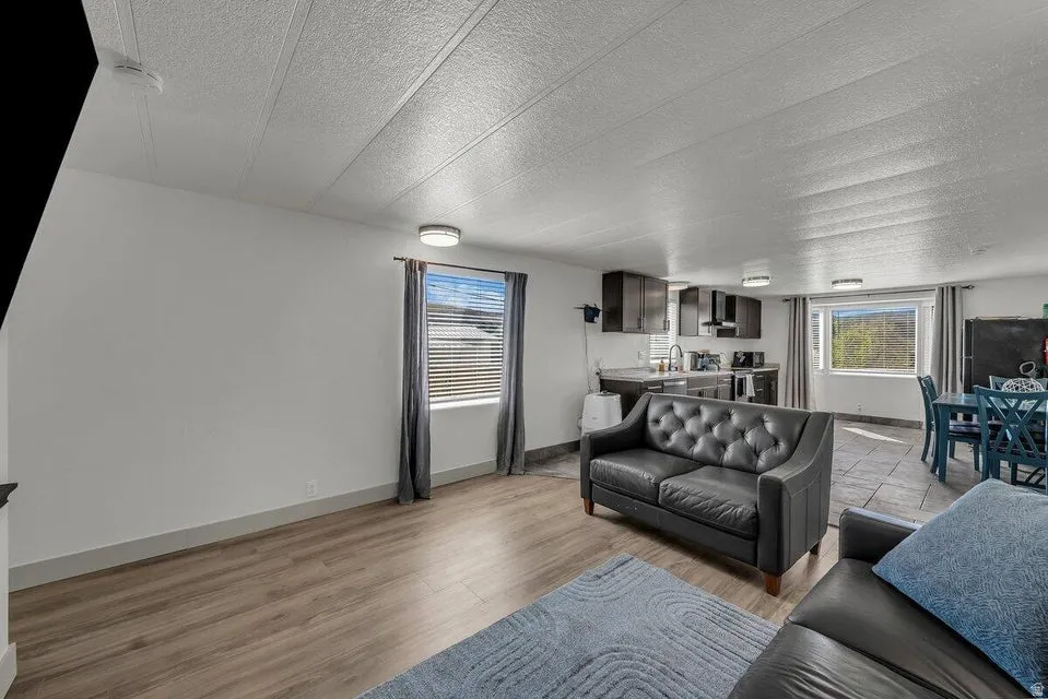 Living area with a textured ceiling and light wood-style flooring