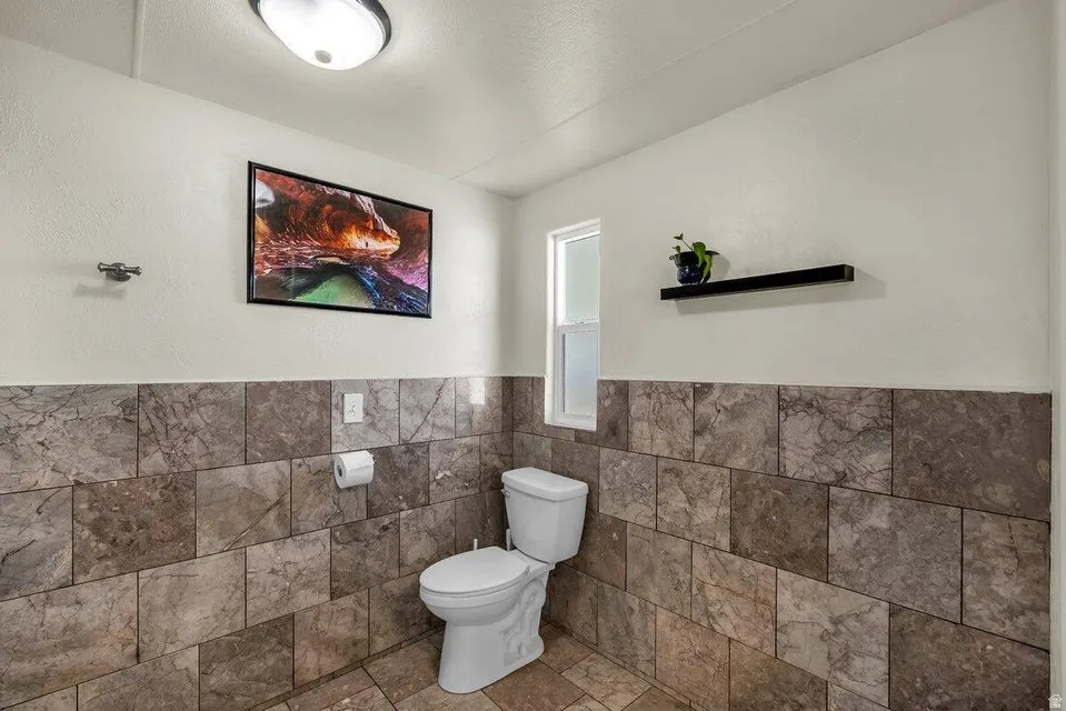 Bathroom with tile walls and a wainscoted wall