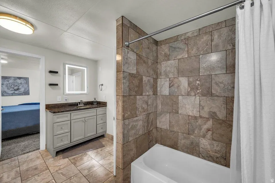 Bathroom with vanity, ensuite bath, and shower / tub combo
