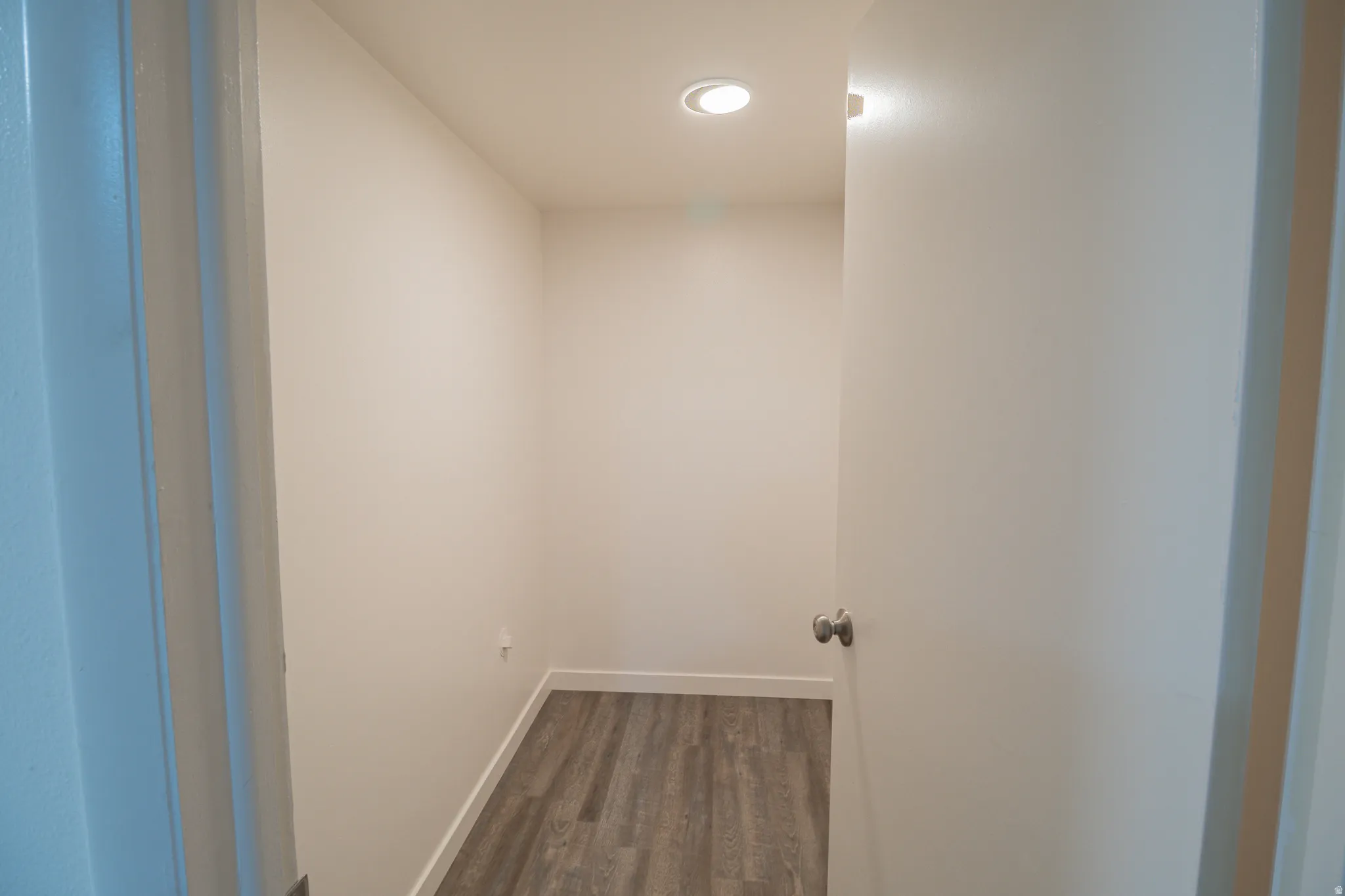 Hallway with dark wood-style floors and baseboards
