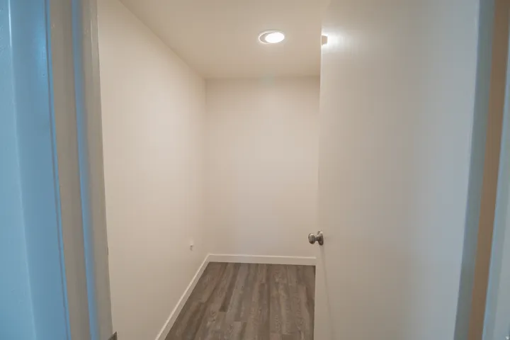 Hallway with dark wood-style floors and baseboards