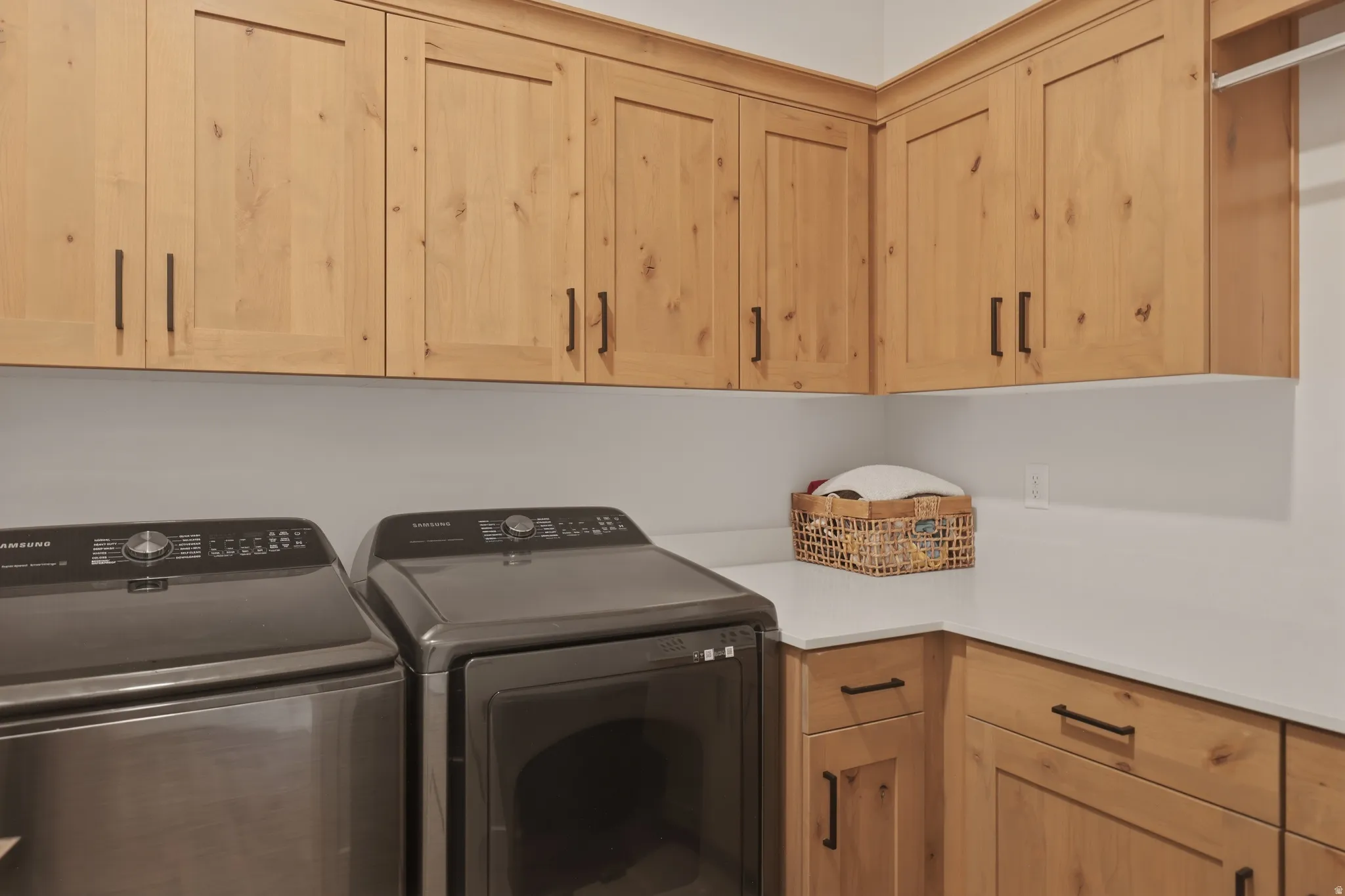 Laundry area featuring separate washer and dryer and cabinet space
