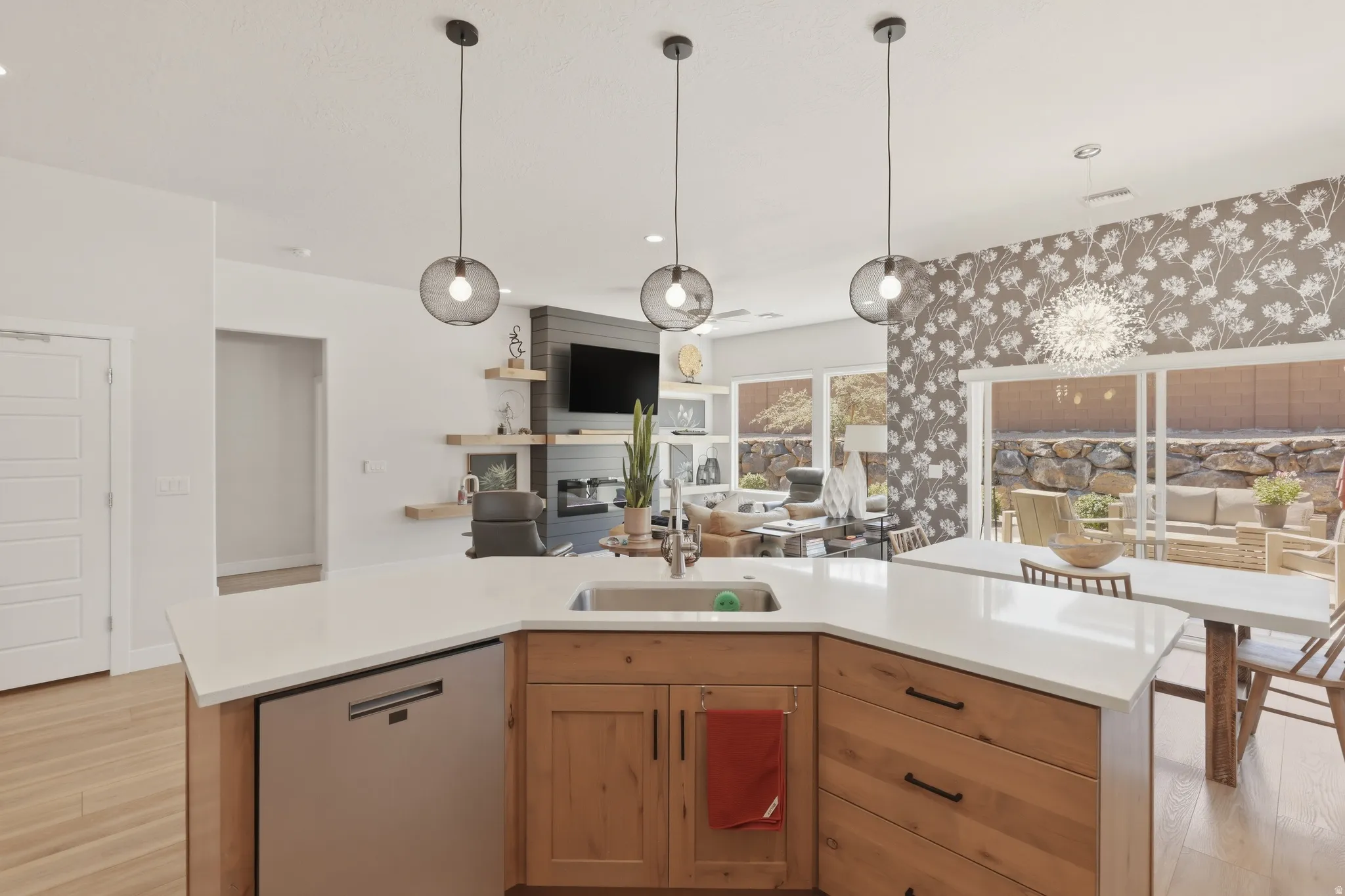 Kitchen with a kitchen island with sink, dishwashing machine, light wood-style flooring, and open floor plan