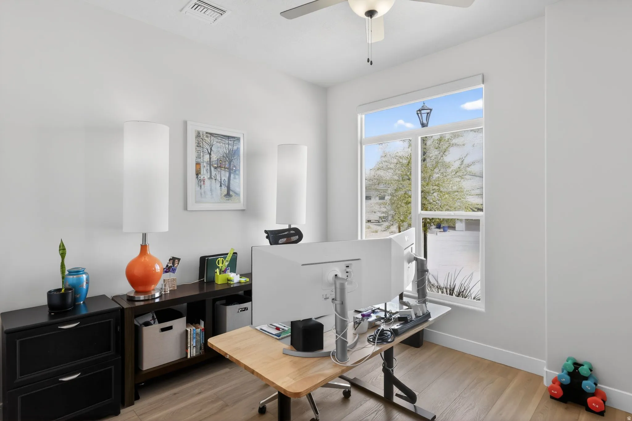 Office area with light wood finished floors and ceiling fan