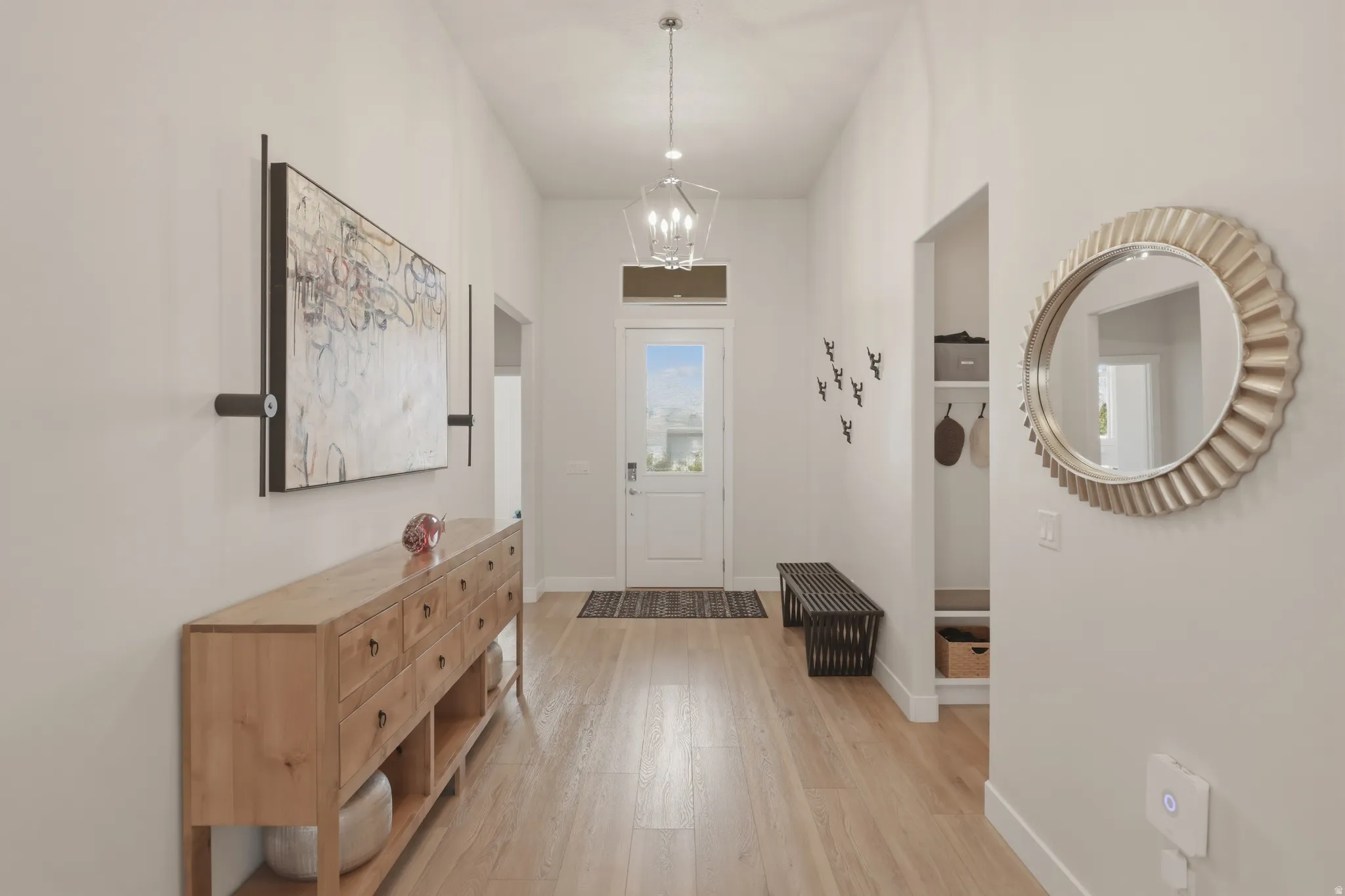 Entrance foyer featuring light wood-type flooring and hanging lights