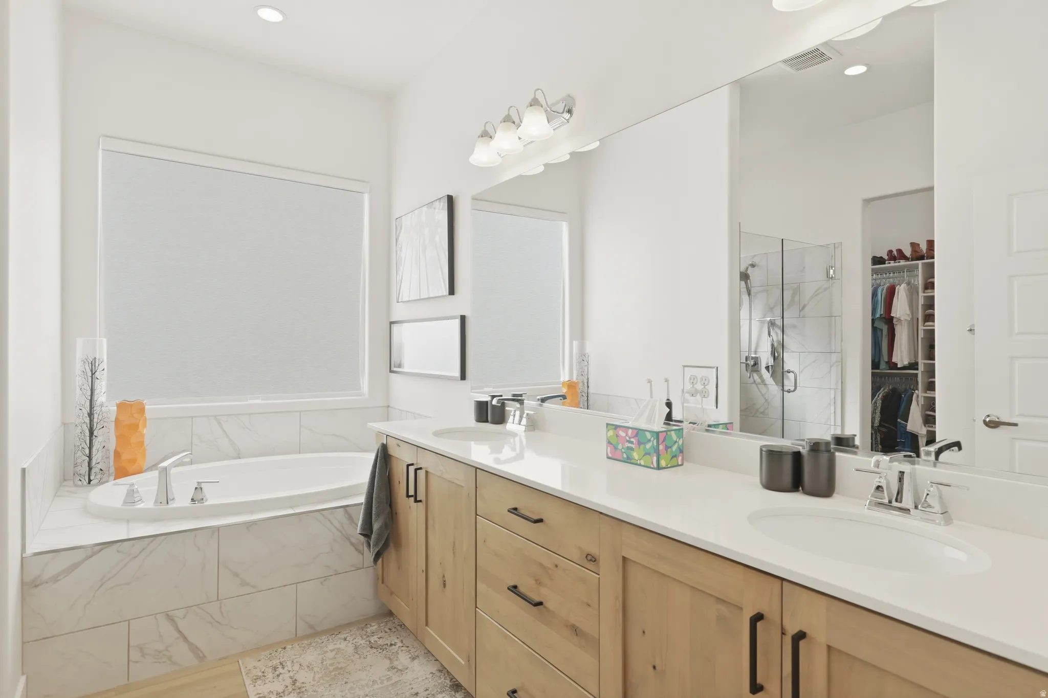 Full bathroom with a marble finish shower, a spacious closet, double vanity, a bath, and recessed lighting