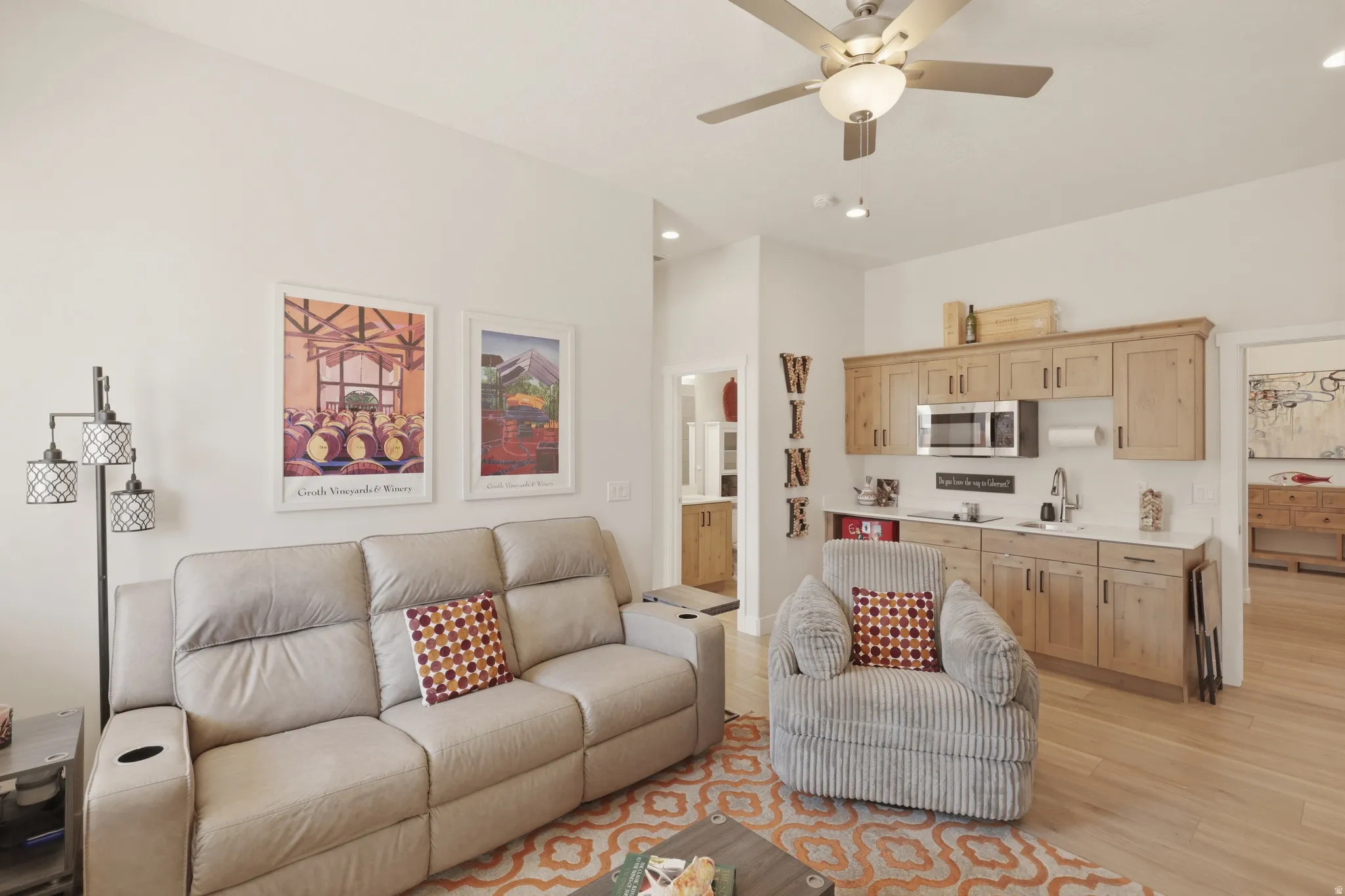 Living area featuring ceiling fan, light wood-style flooring, recessed lighting, and a high ceiling
