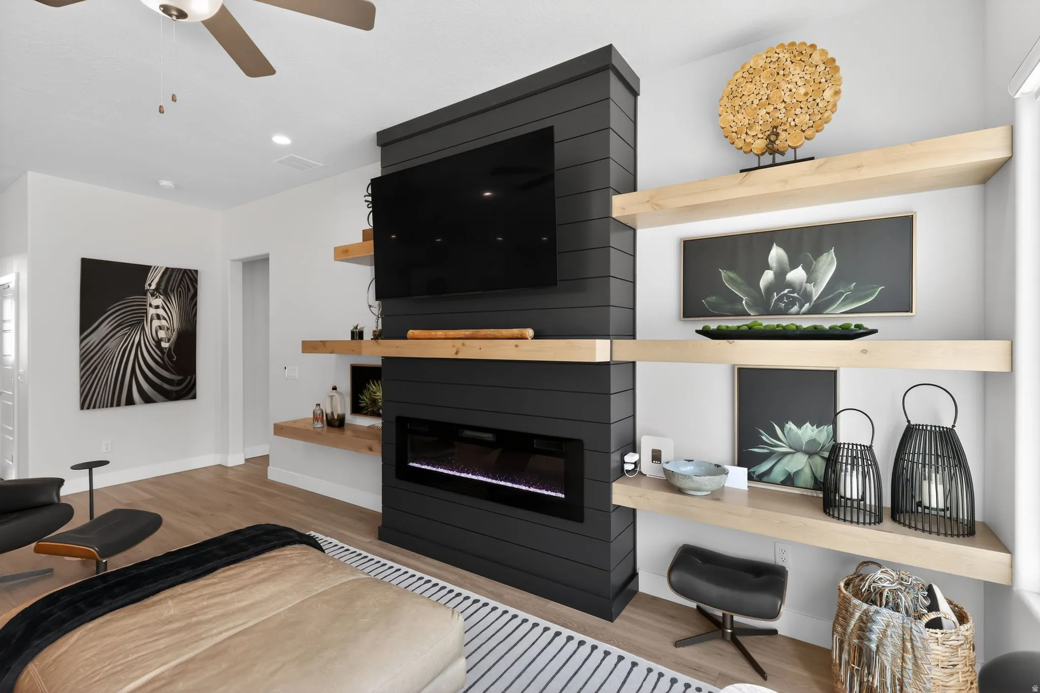 Living room featuring a large fireplace, light wood-type flooring, a ceiling fan, and recessed lighting