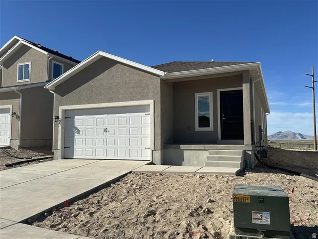 View of front of house featuring an attached garage, driveway, stucco siding, and a porch