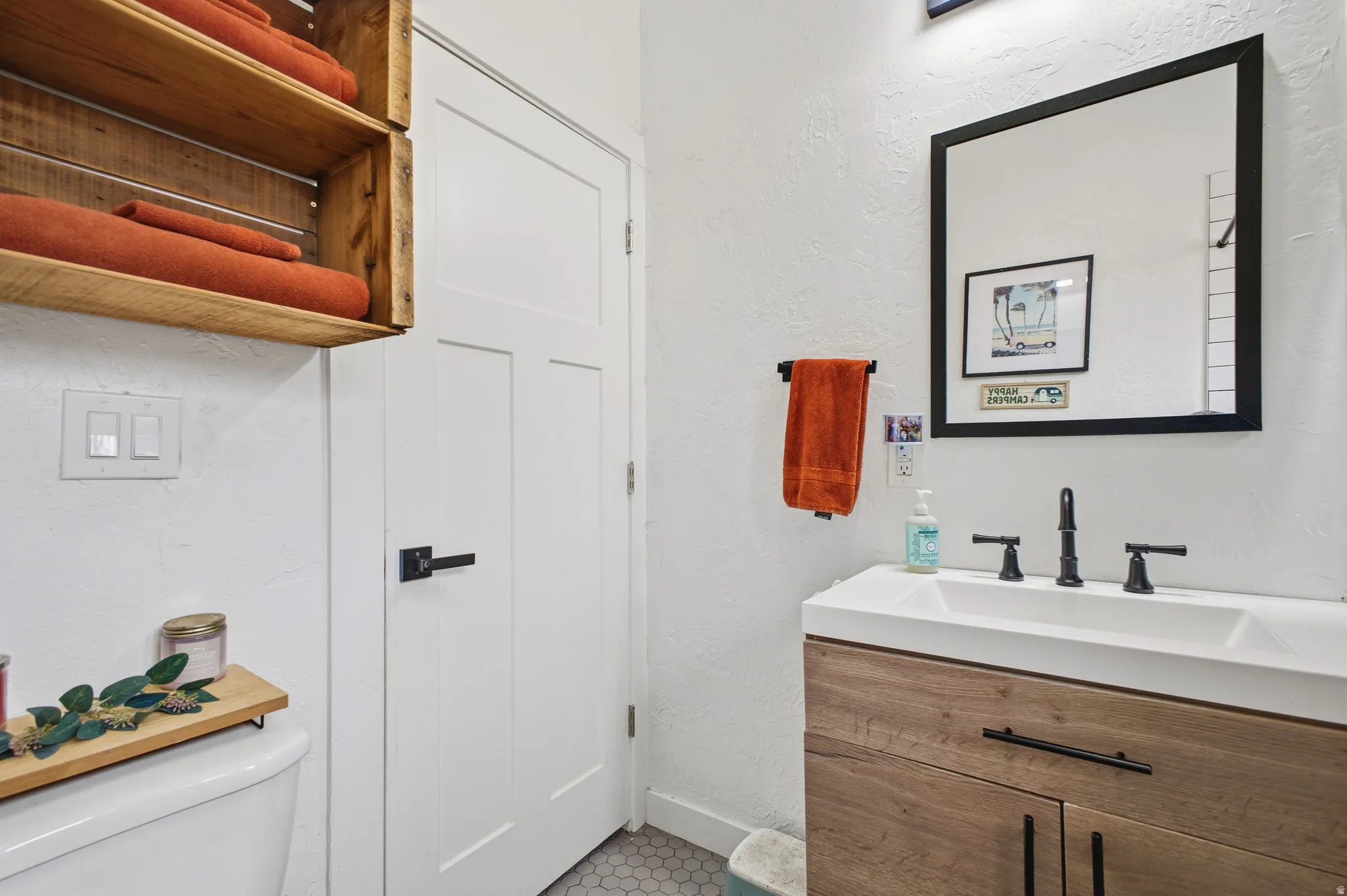 Bathroom with a textured wall and vanity