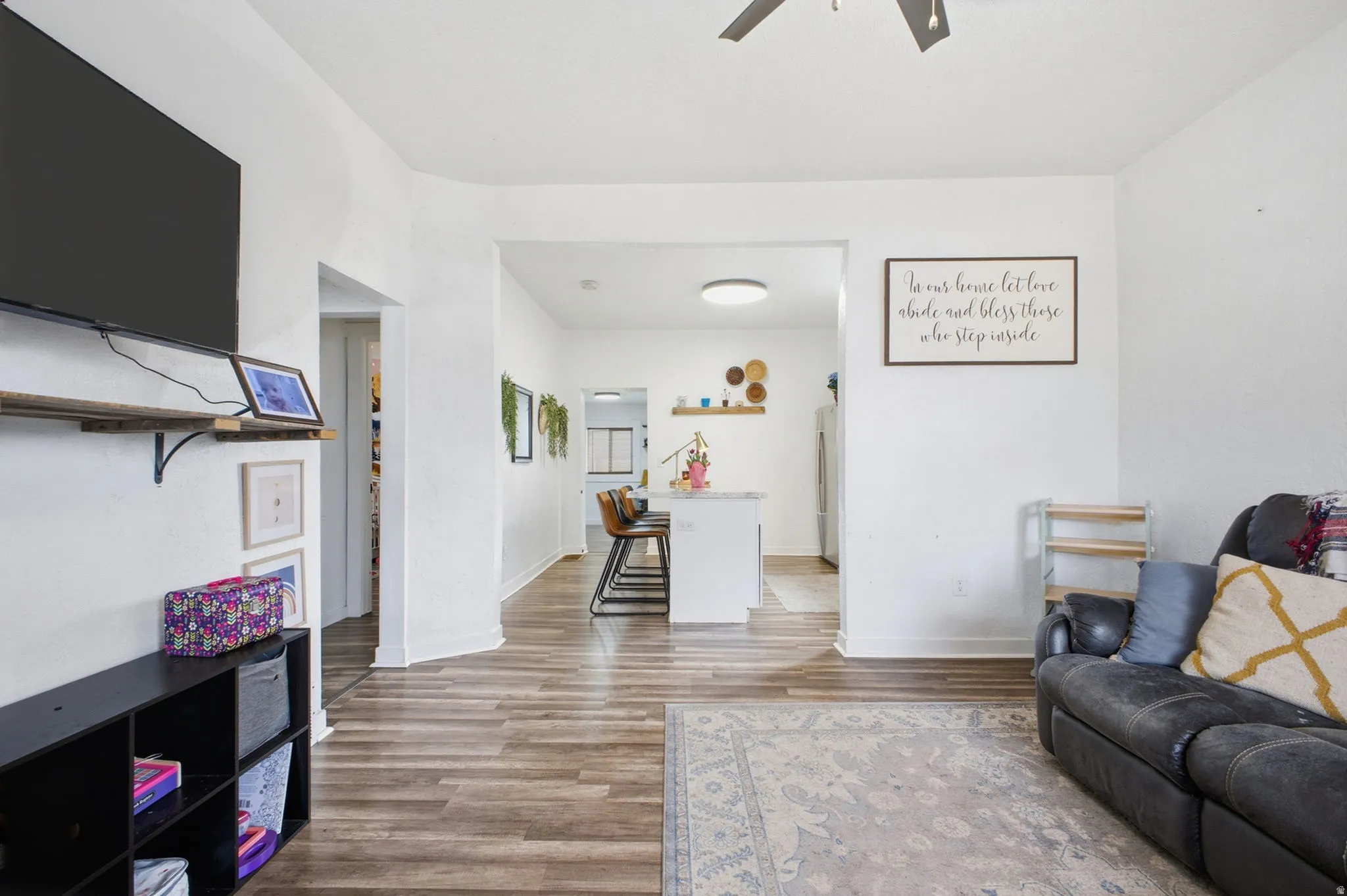 Living area with light wood finished floors and ceiling fan