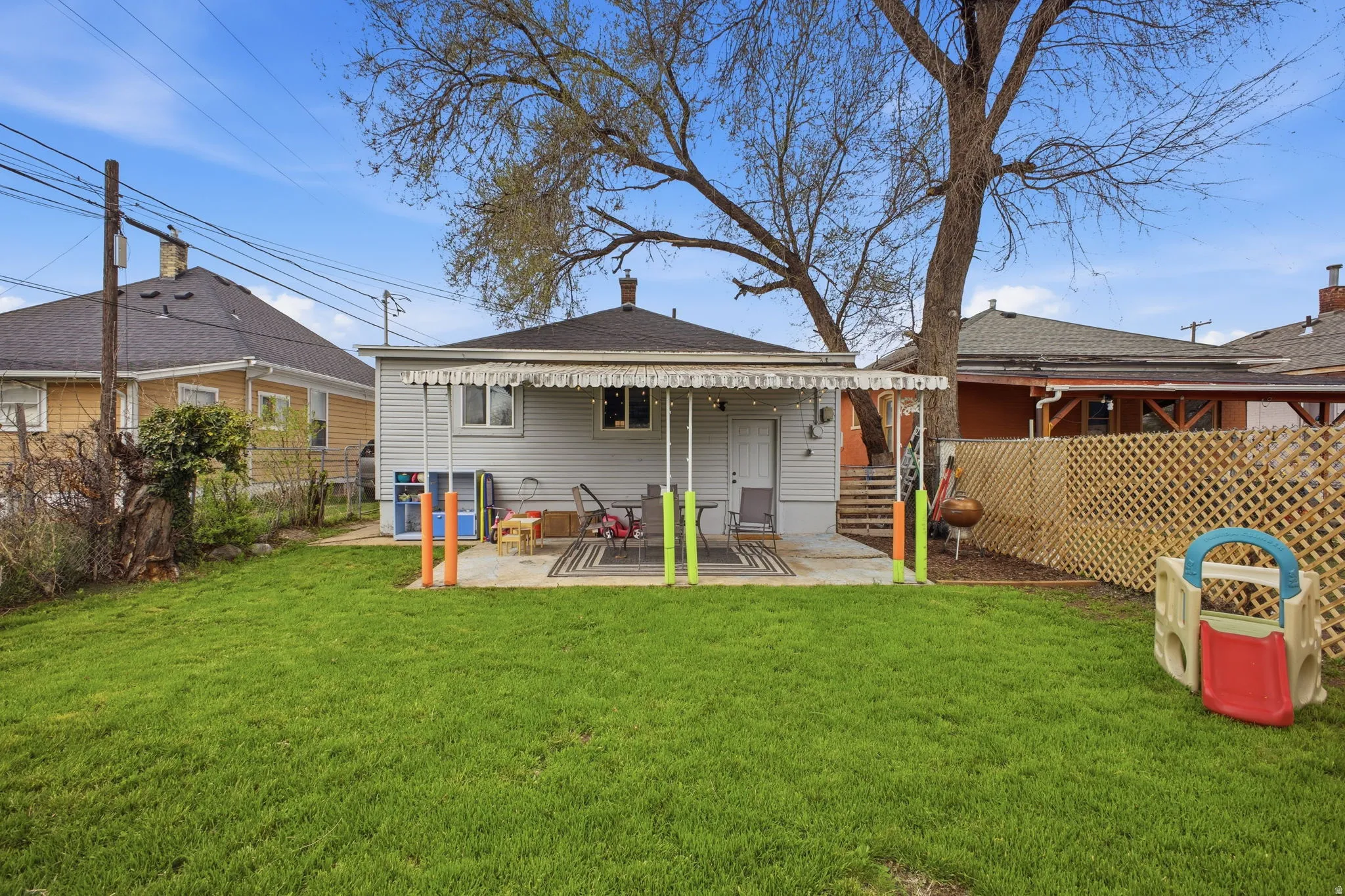 Rear view of property featuring a fenced backyard, a patio area, a chimney, and a shingled roof