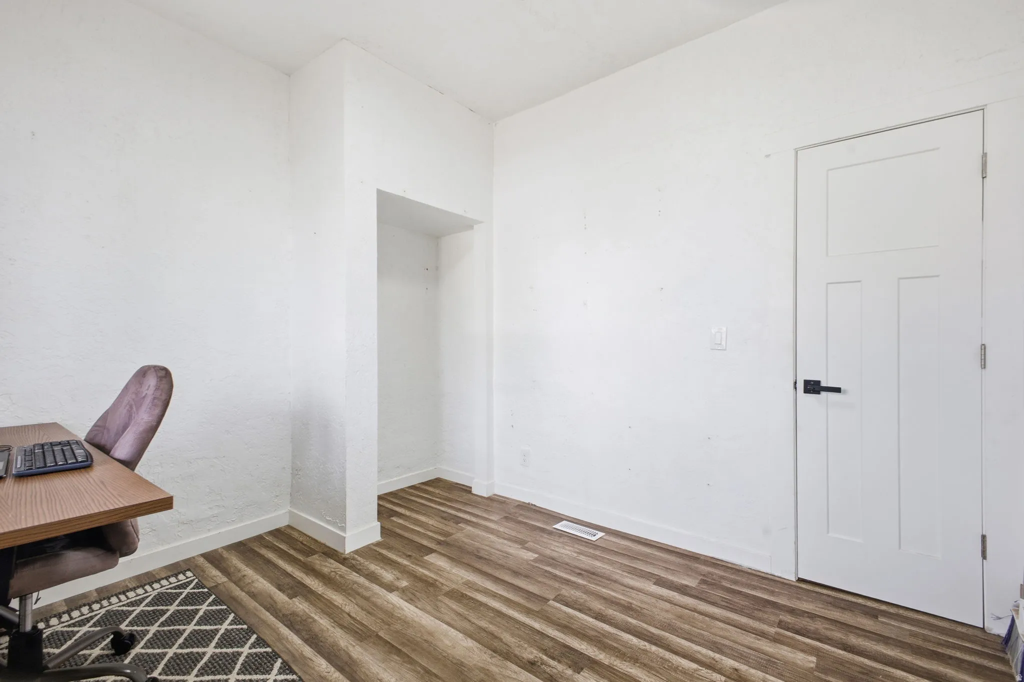 Unfurnished office with wood finished floors and baseboards