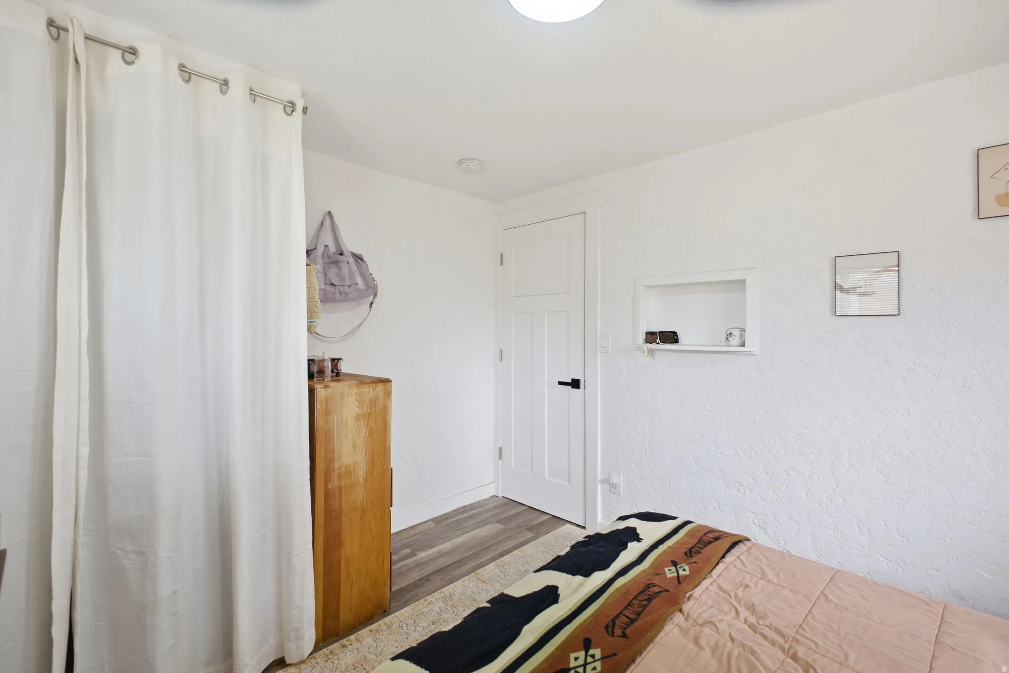 Interior space featuring light wood finished floors and a textured wall