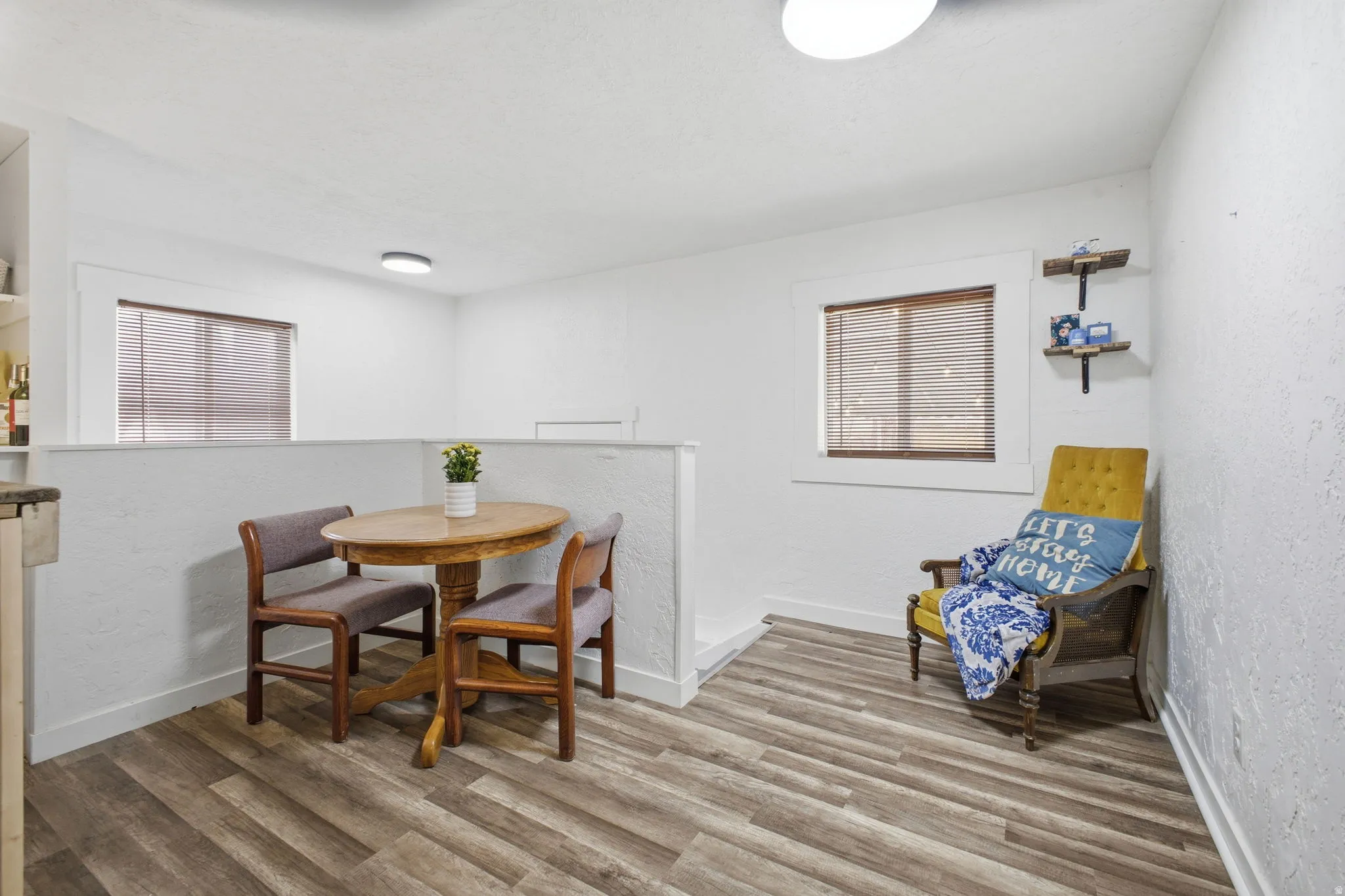 Dining area featuring a textured wall and light wood-type flooring
