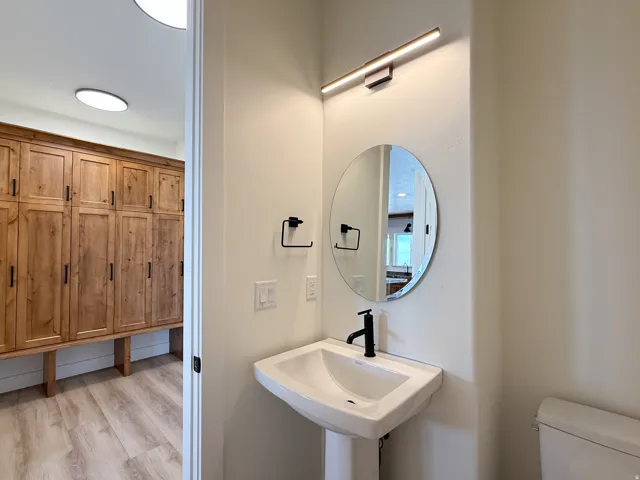 Half bath with toilet and light wood finished floors