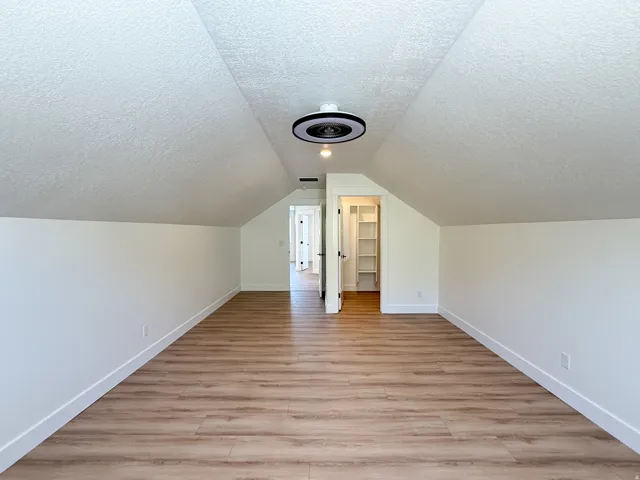 Bonus room with a textured ceiling and light wood-style floors