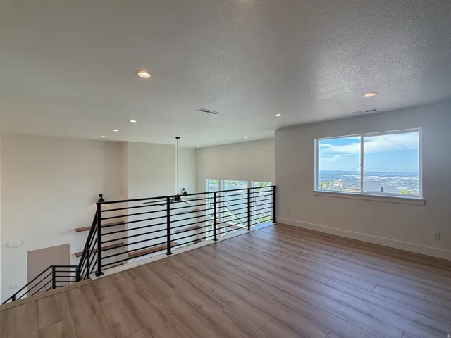 Empty room featuring a textured ceiling, recessed lighting, and light wood-type flooring