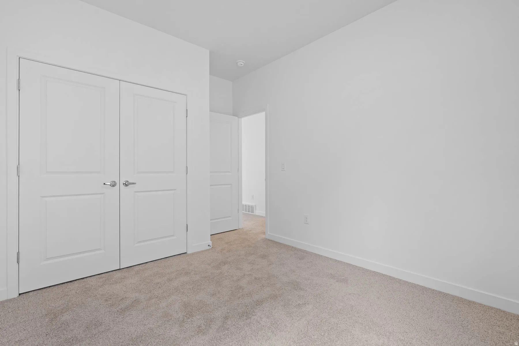 Neutral toned carpeting complements the white walls and trim