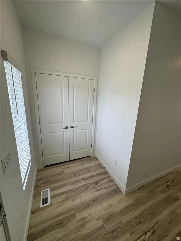 Unfurnished bedroom with light wood-type flooring and a closet