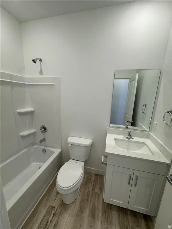 Bathroom featuring vanity, light wood-style floors, and bathing tub / shower combination