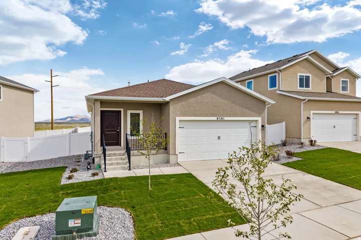 Contemporary stucco exterior with an attached garage and a concrete driveway