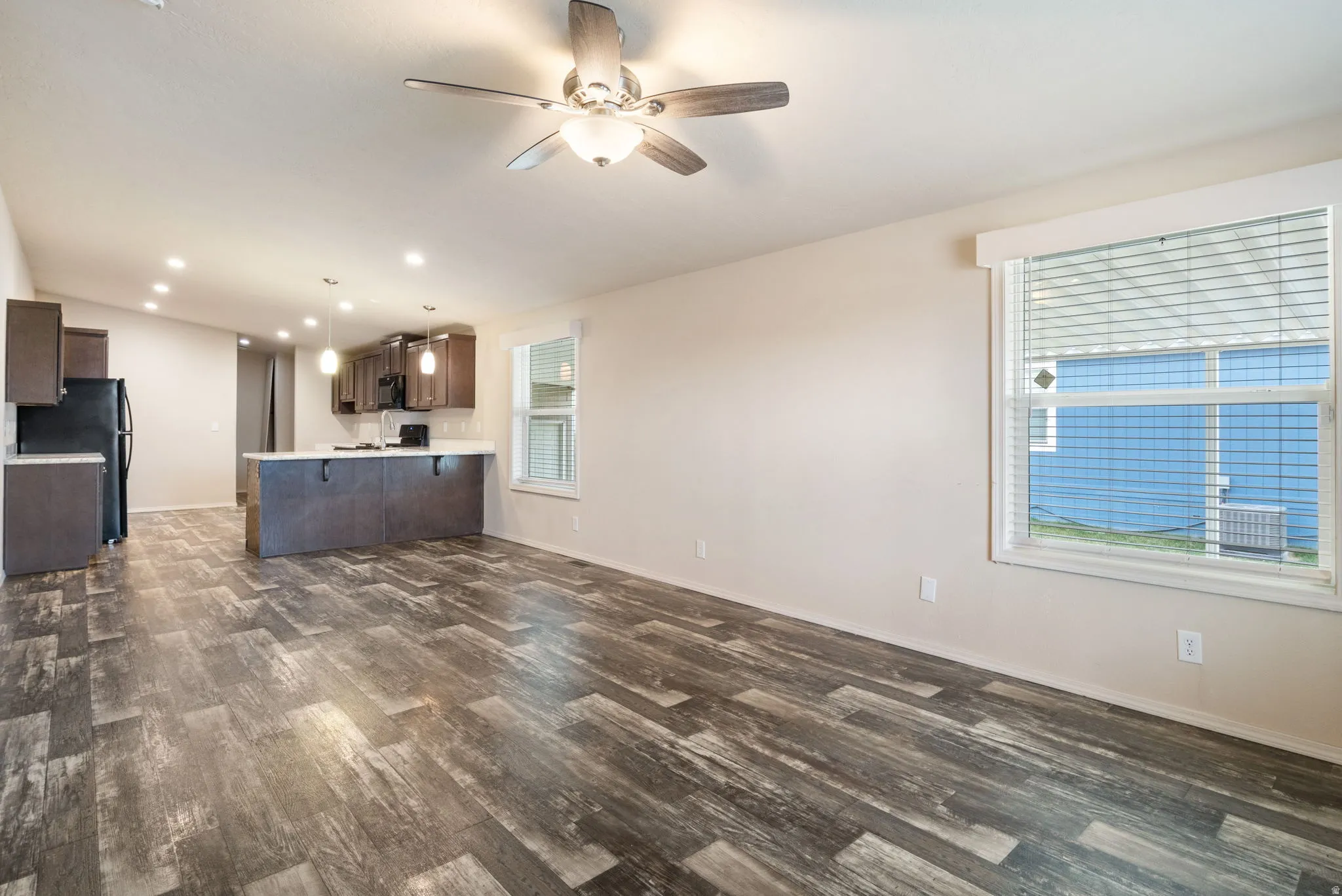 Unfurnished living room with recessed lighting, a ceiling fan, and dark wood-type flooring