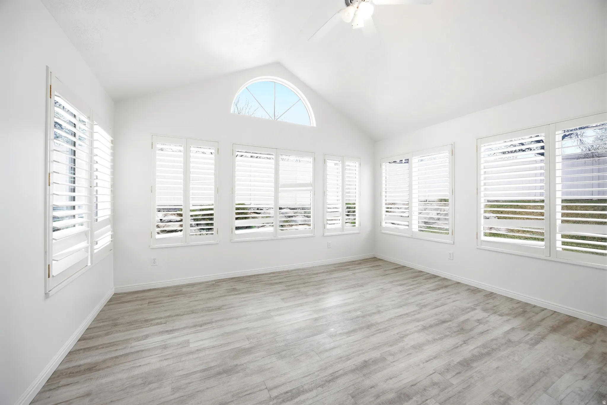 Unfurnished sunroom featuring wood finished floors and baseboards