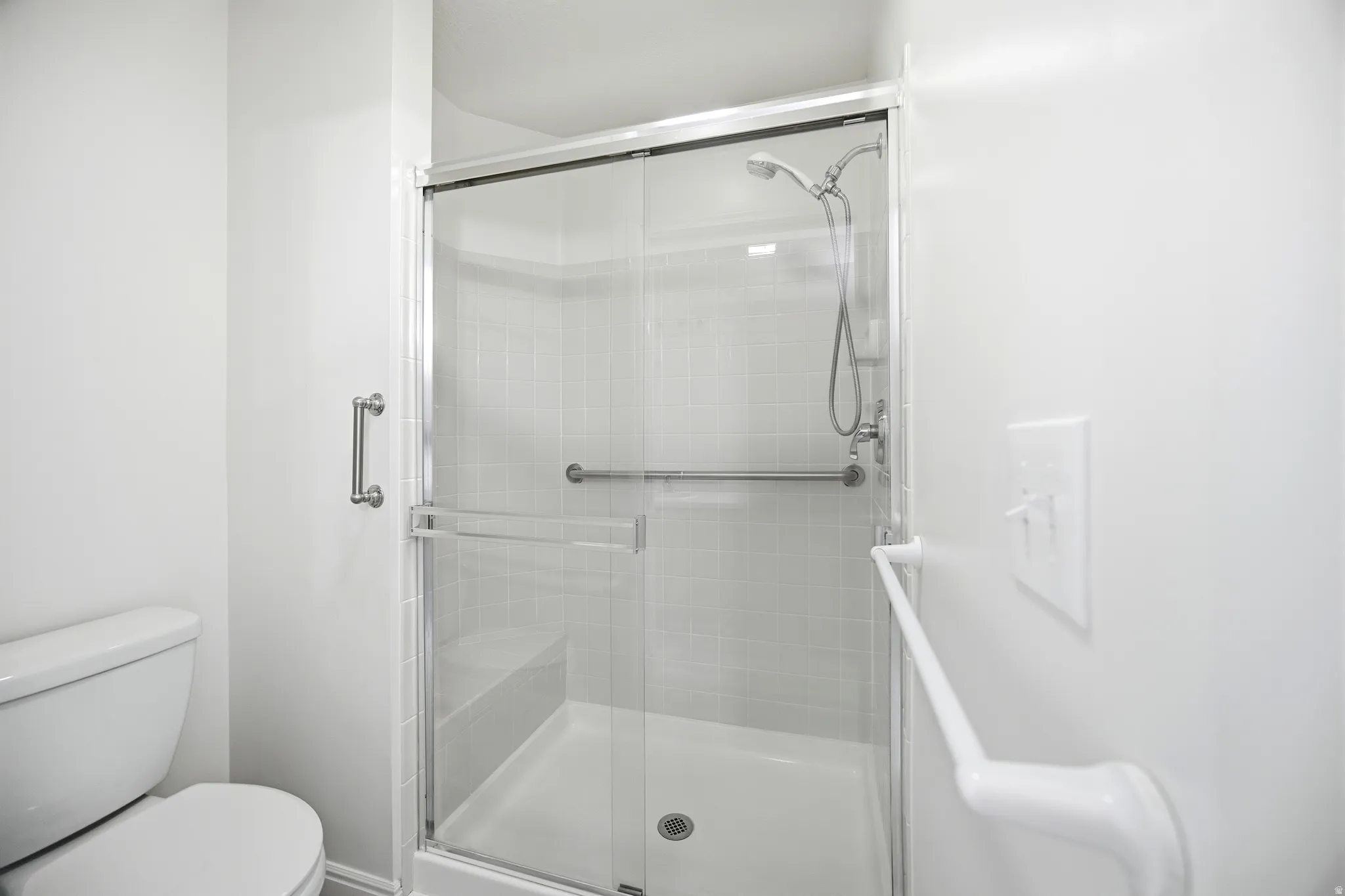 Full bathroom with toilet and a shower stall