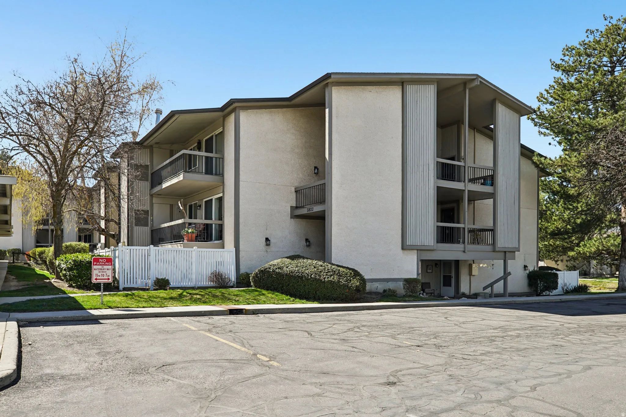 View of apartment building / complex featuring uncovered parking