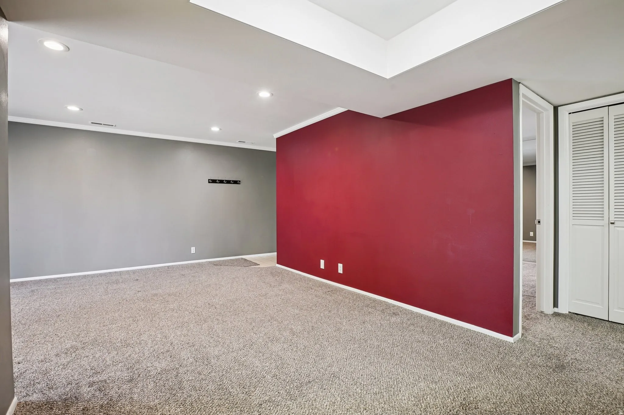 Empty room featuring carpet, recessed lighting, and crown molding